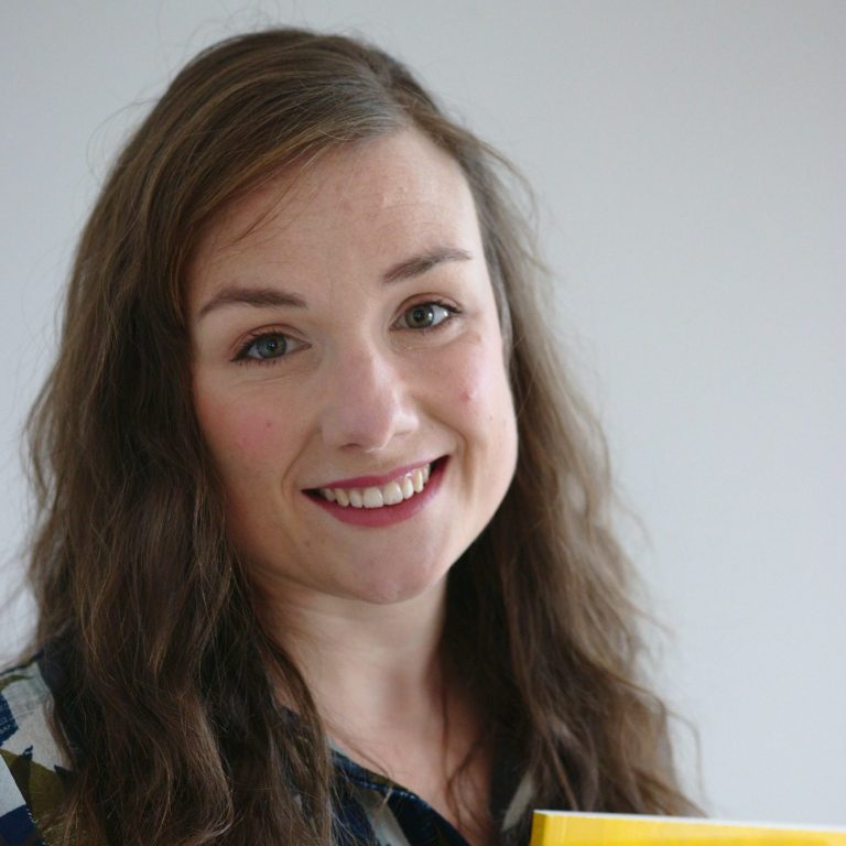 Emily Fox is smiling at the camera against a white background